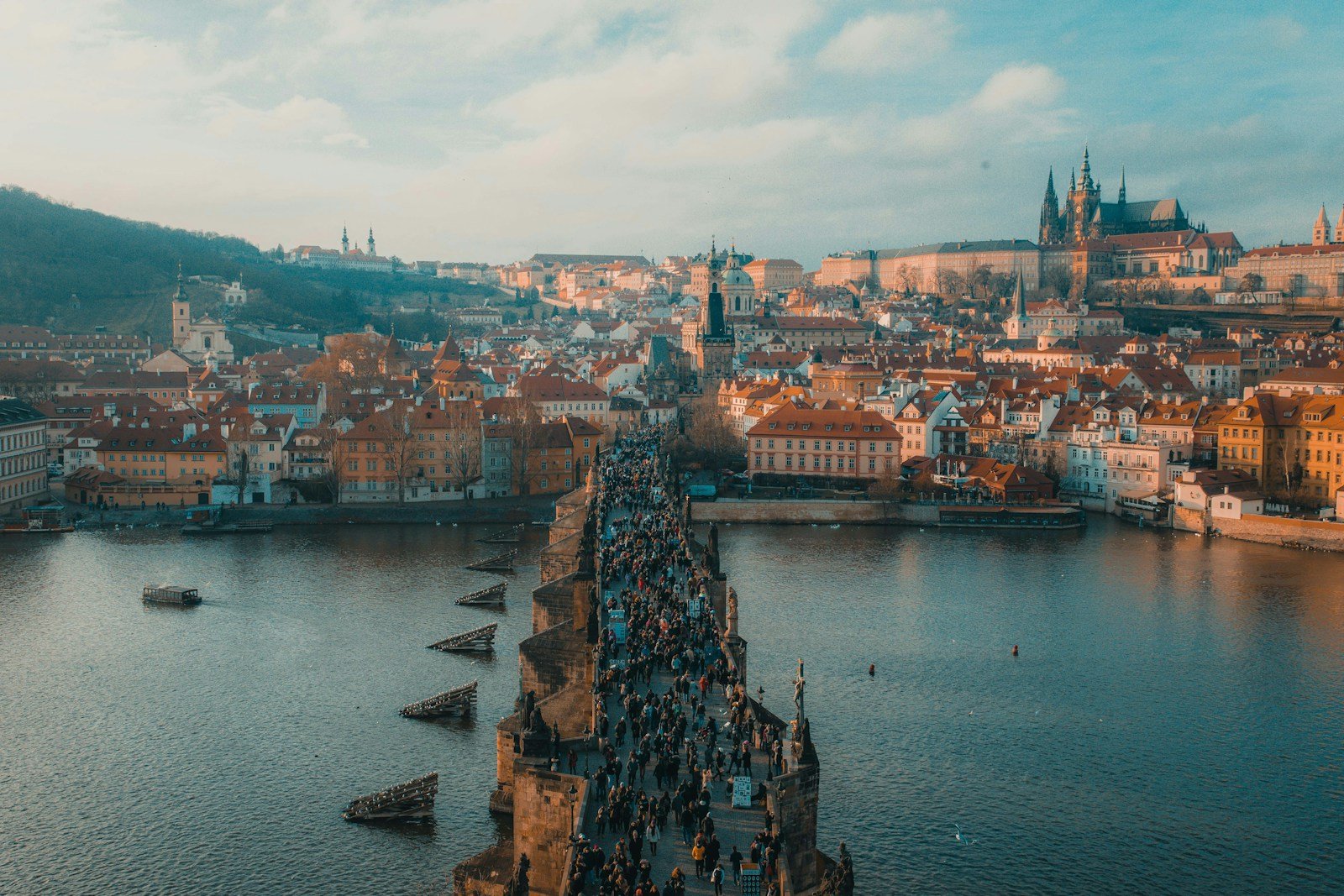 a bridge over water with many people walking on it